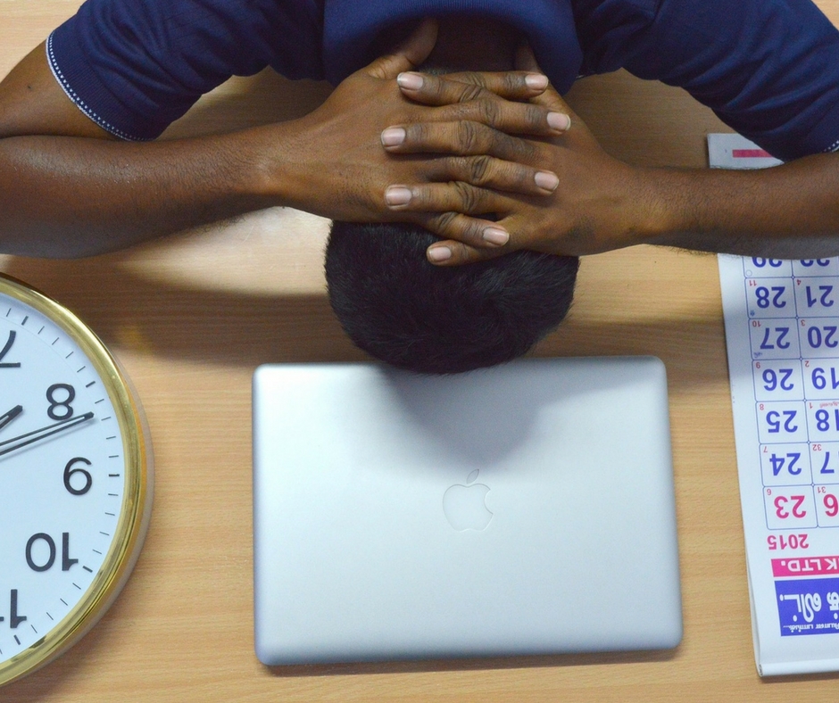 man surrounded by clocks stressed