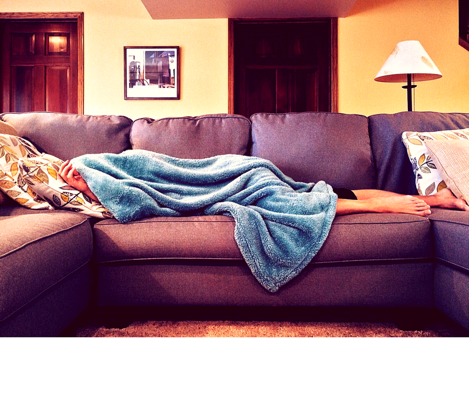 girl under blanket on sofa low energy